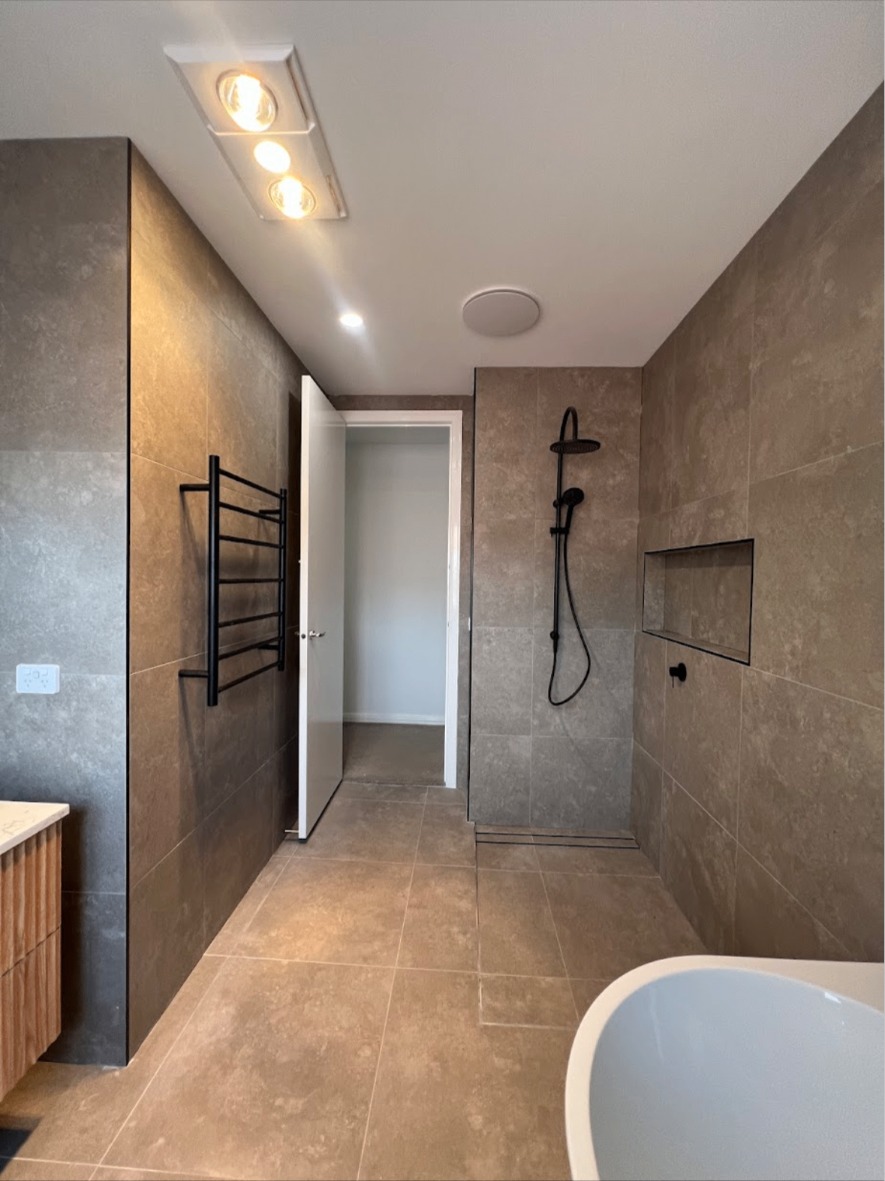 Modern bathroom tiled floor to ceiling in stone-look tiles