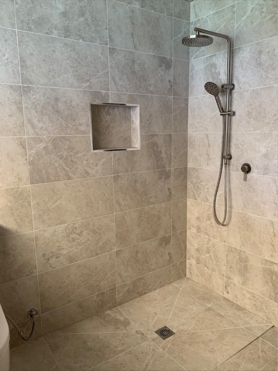 Marble-look tiled shower with recessed niche